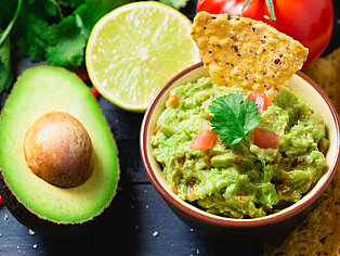 Eine frische Guacamole mit Limette und Tomaten